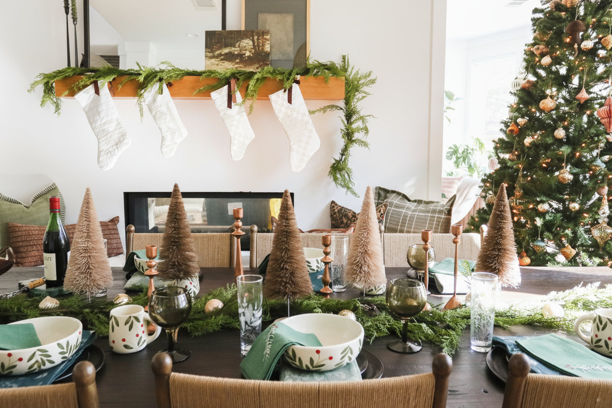 Dining room with Christmas decorations, including a tree and stockings on the wall.